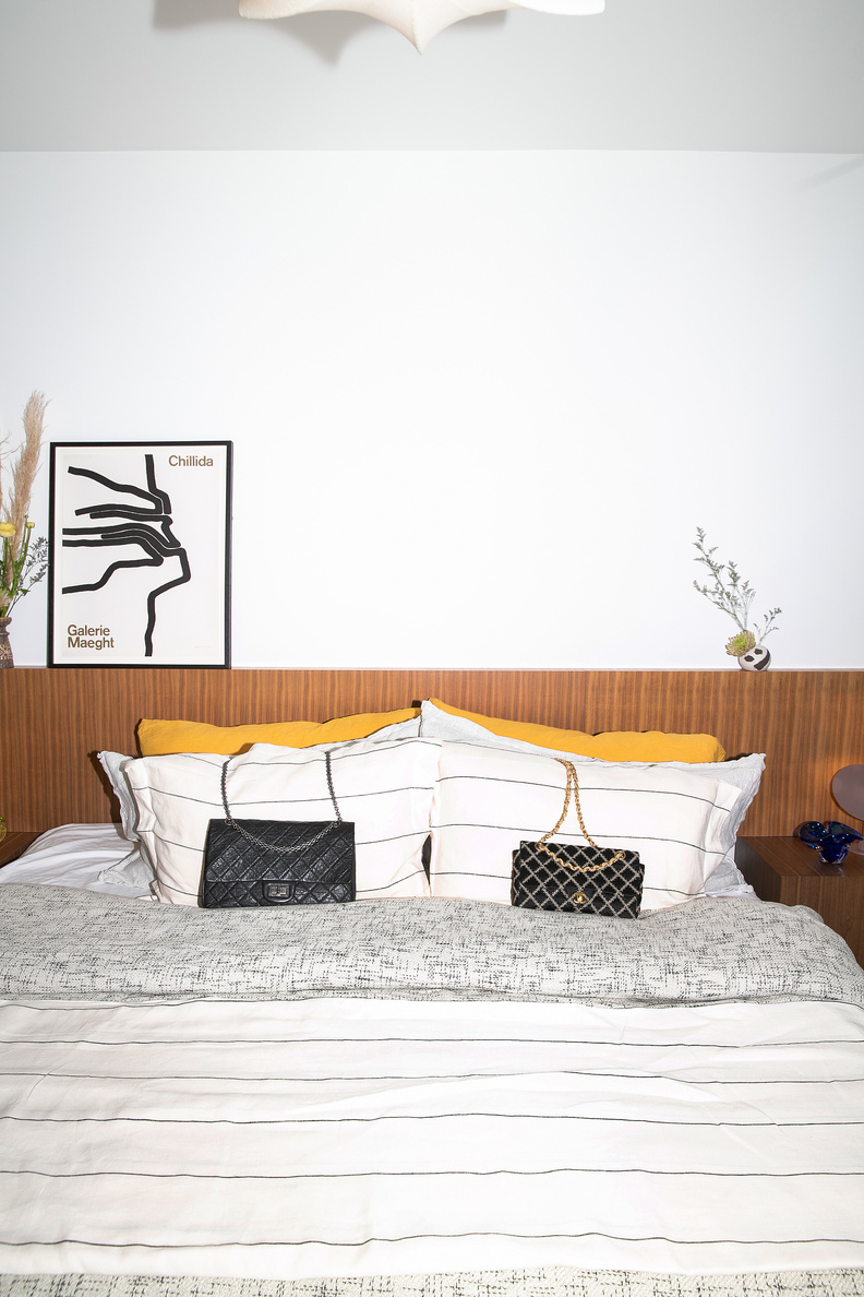 Two handbags styled on a white bed