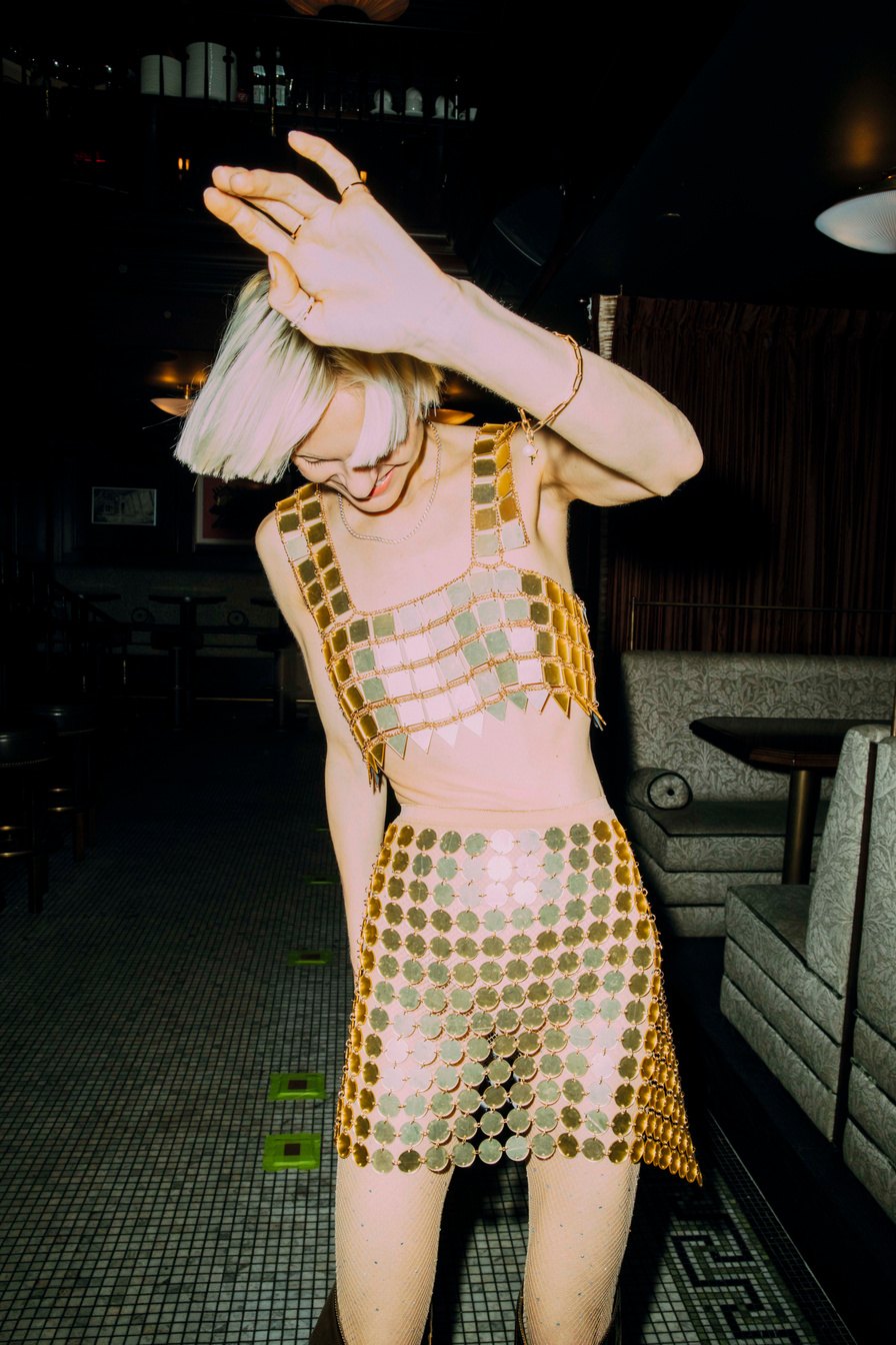 Model dancing in a gold sequinned dress