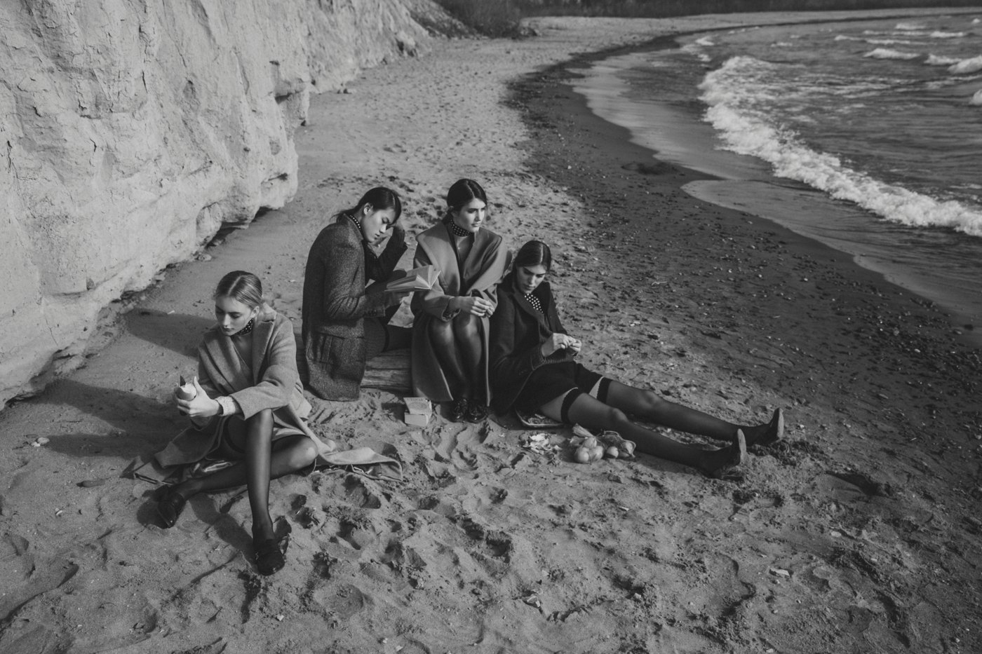 Four women sitting on a beach
