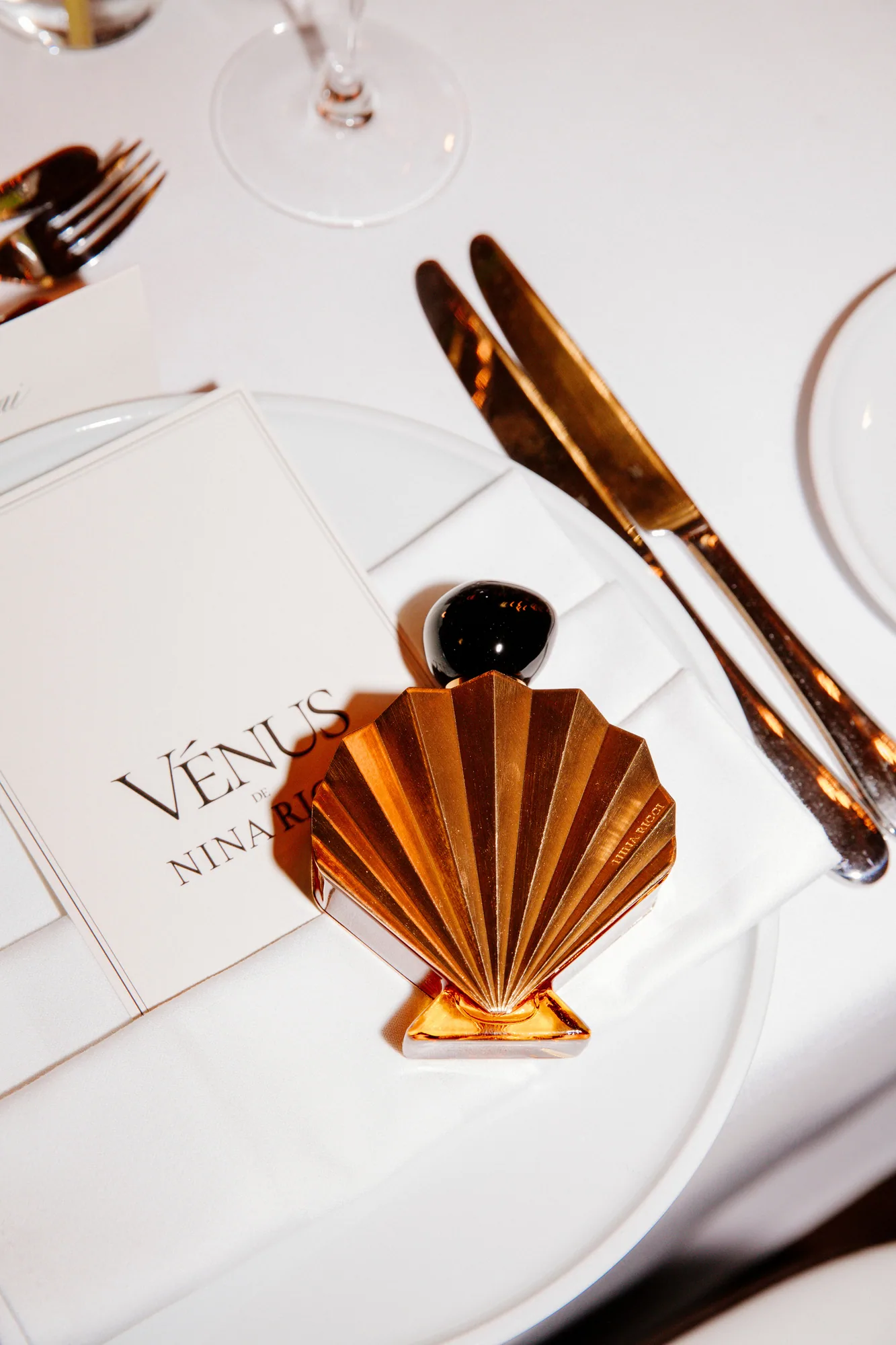 Table setting with an amber shell-shaped clutch and gold cutlery
