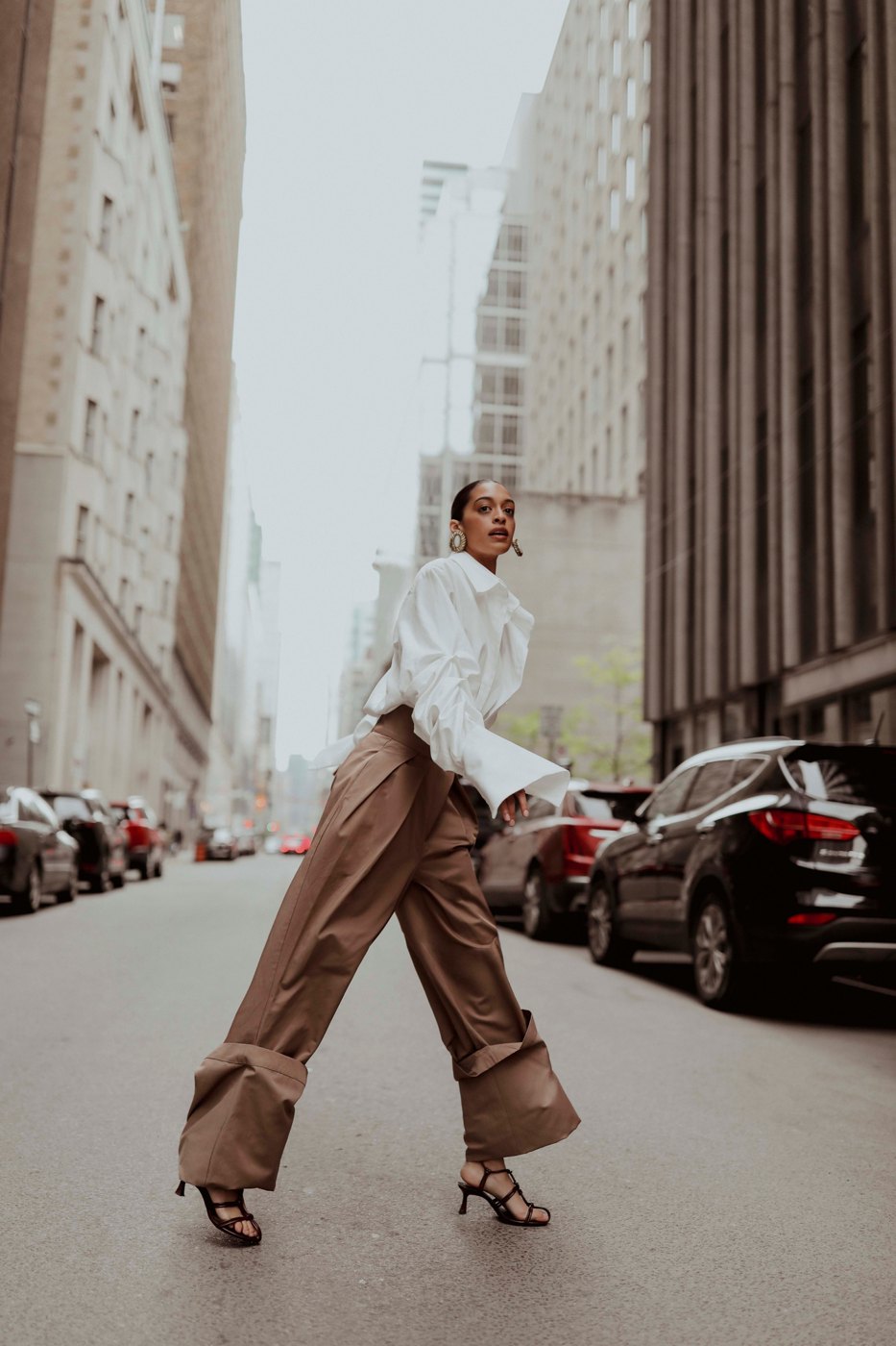 Woman walking down a city street in a white shirt