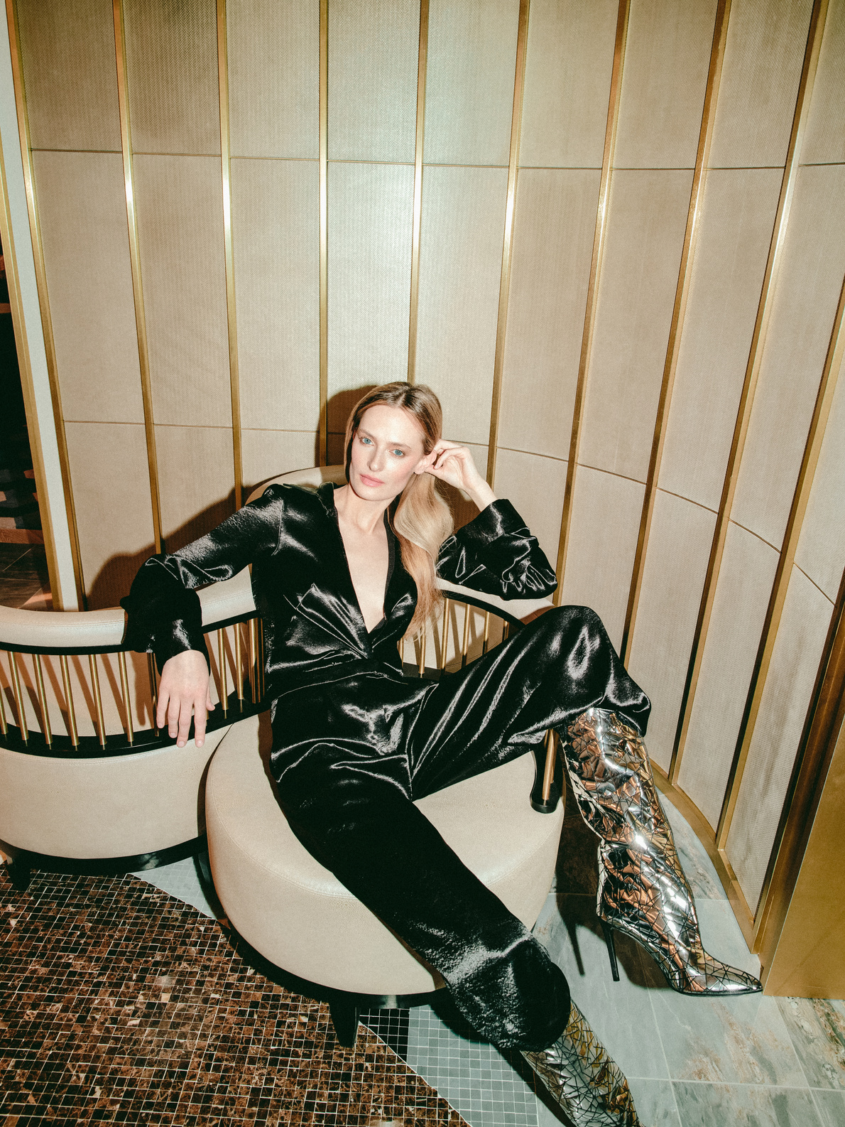 Woman in a black satin suit seated beside a festive table