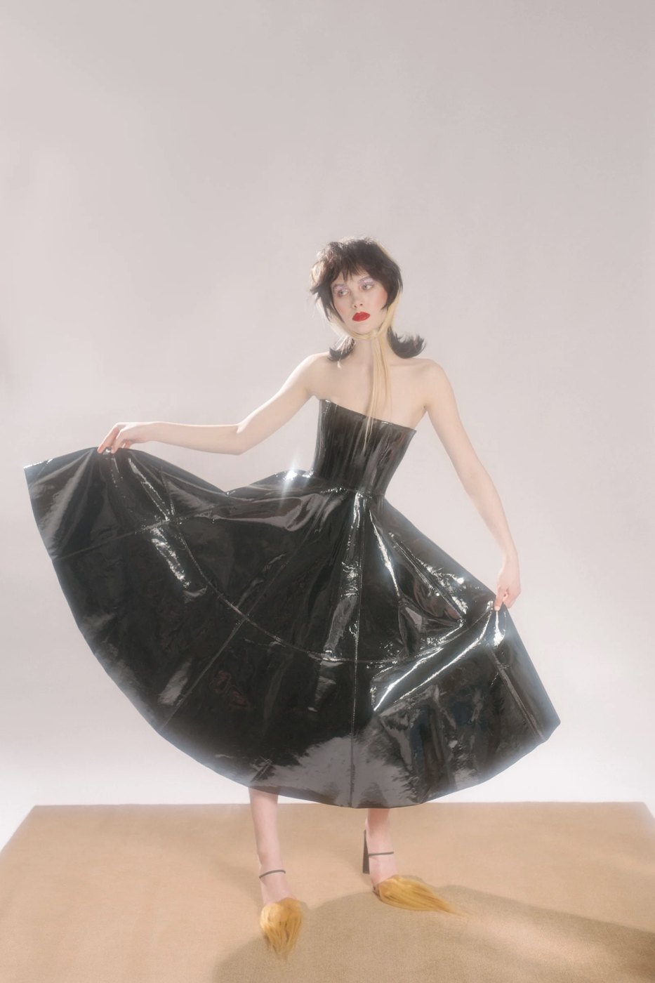 Model in a black patent strapless dress