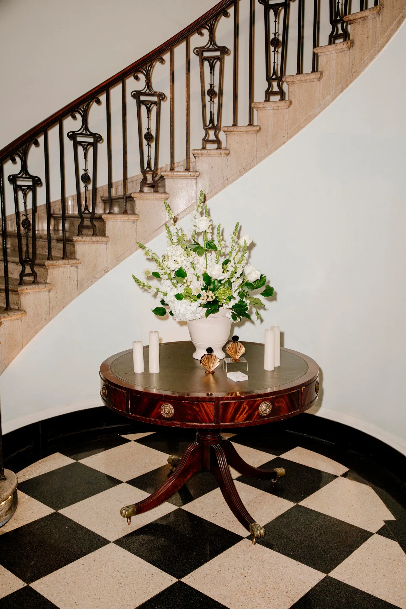Flowers and candles on a table at the foot of a staircase