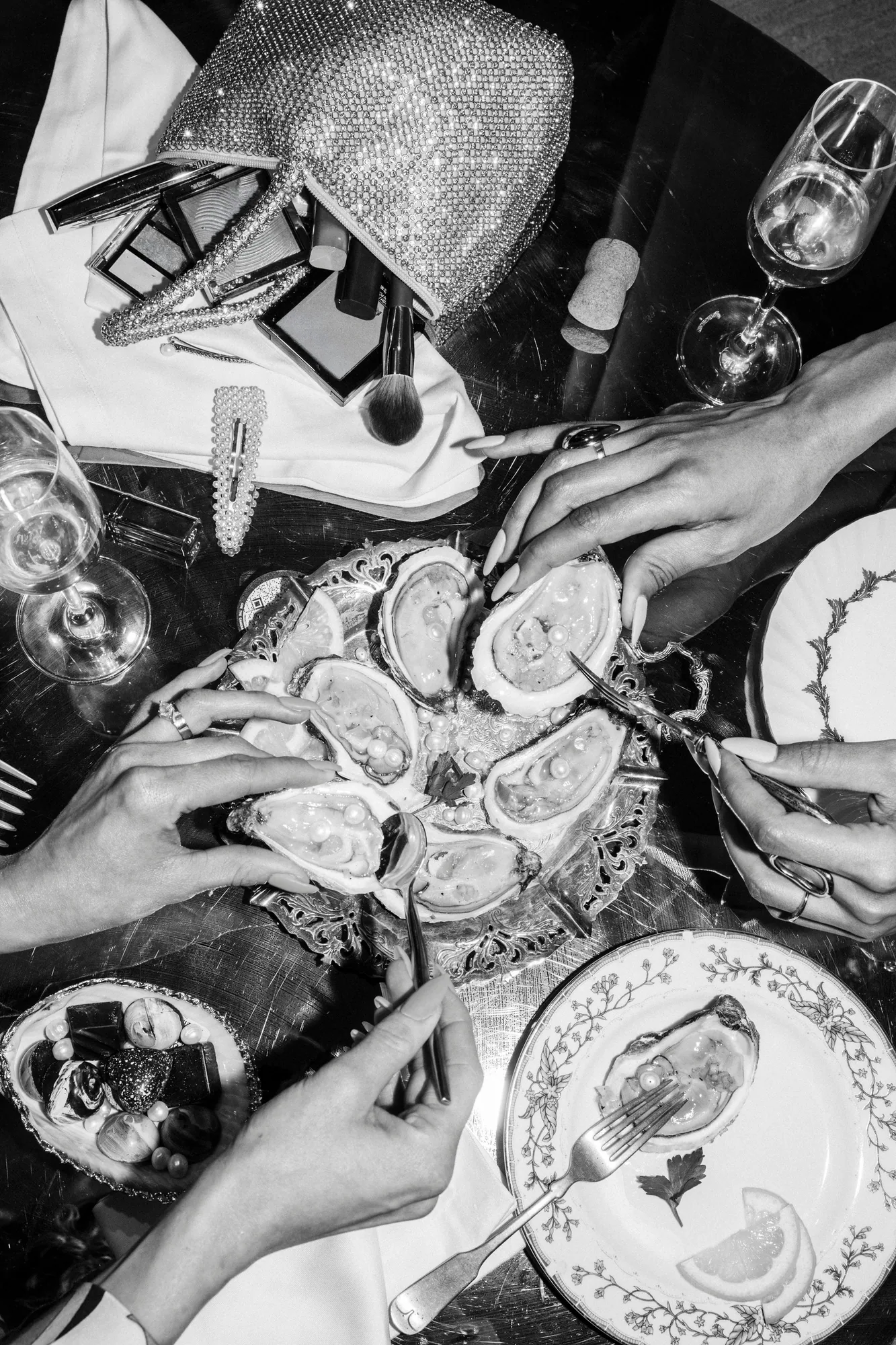Black and white overhead shot of oysters and drinks at a dinner table