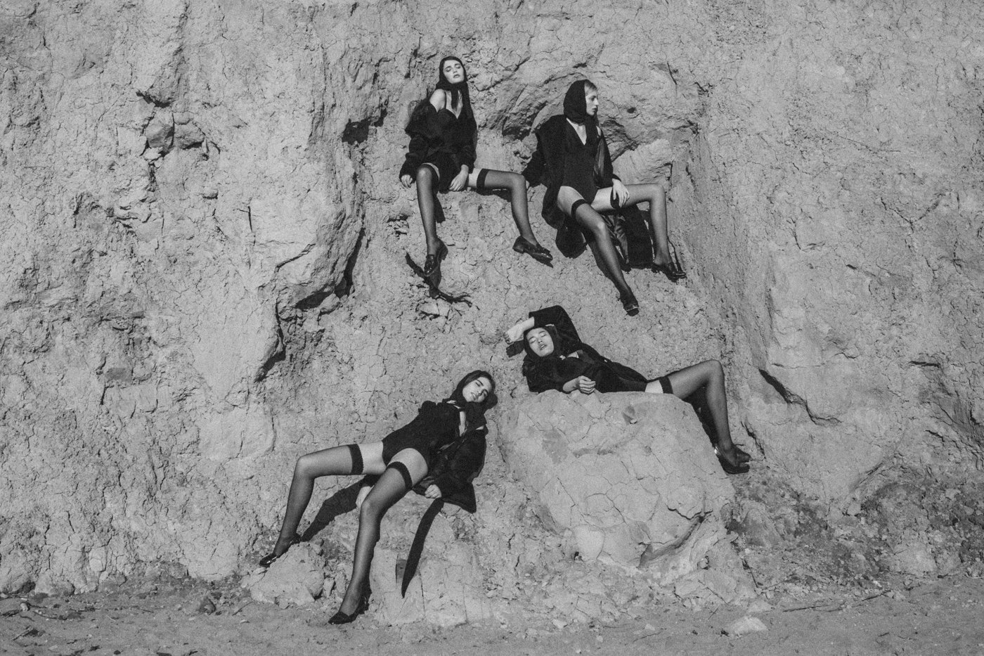 Four models posing in a rocky landscape