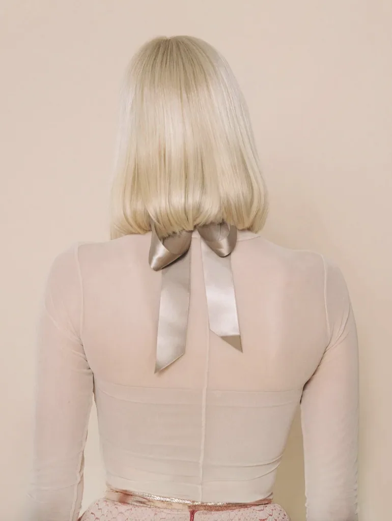 Blonde bob photographed from behind with a champagne satin bow