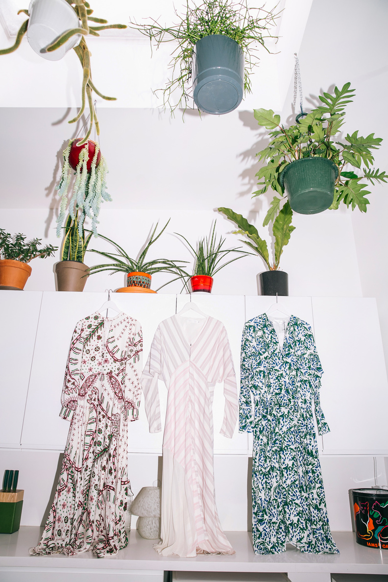 Three dresses displayed among hanging plants