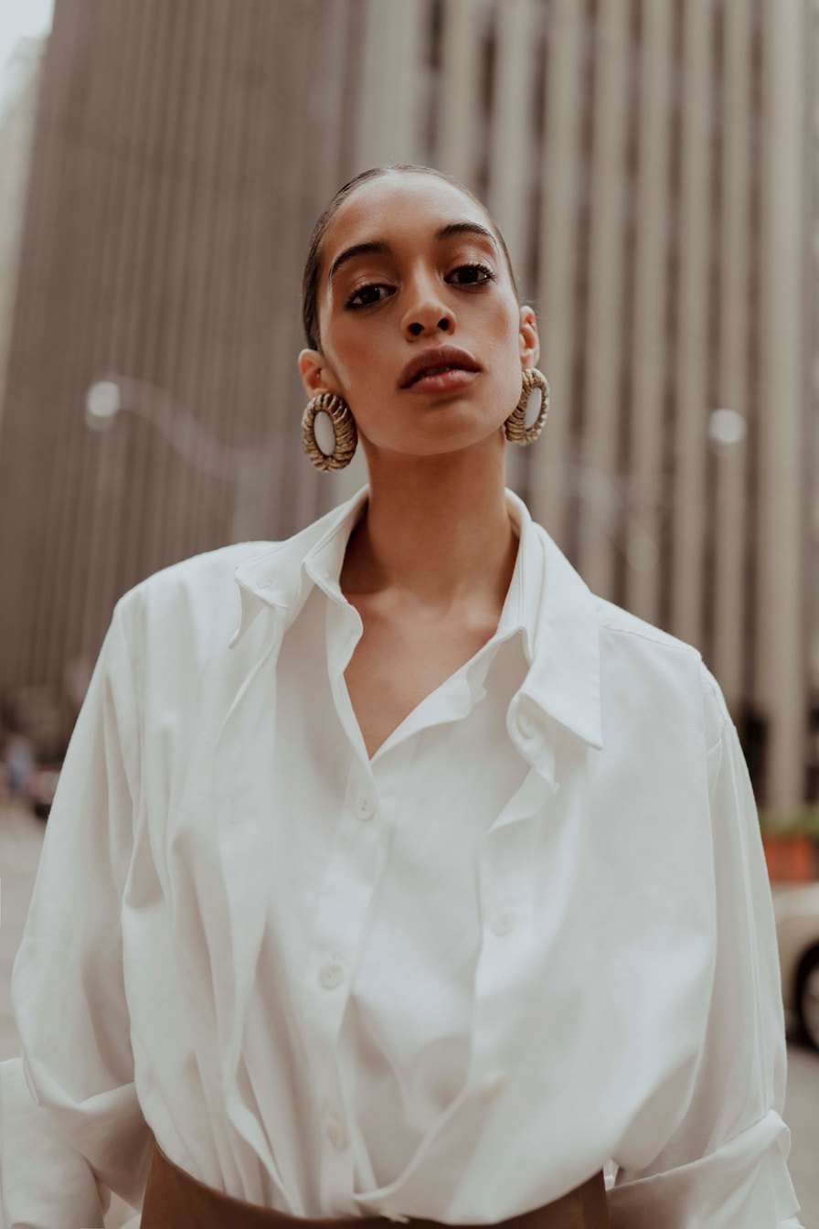 Portrait of a woman in a white shirt and hoop earrings