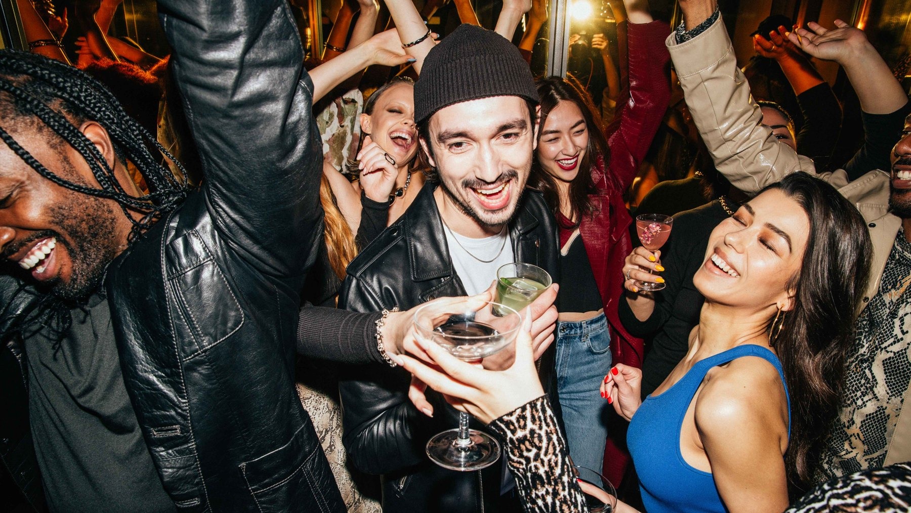 Guests dancing with cocktails at a crowded night party