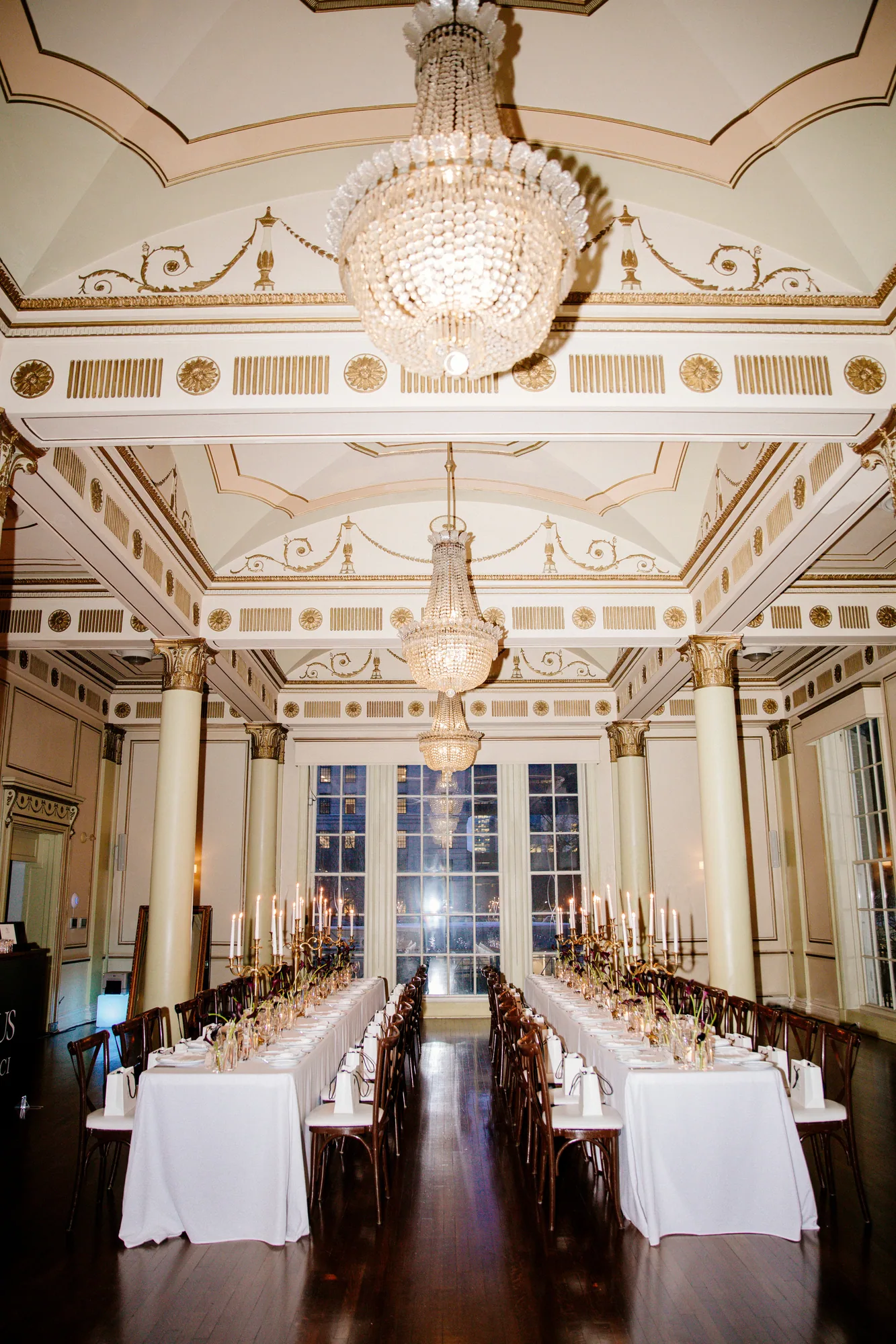 Grand ballroom set for a banquet beneath chandeliers