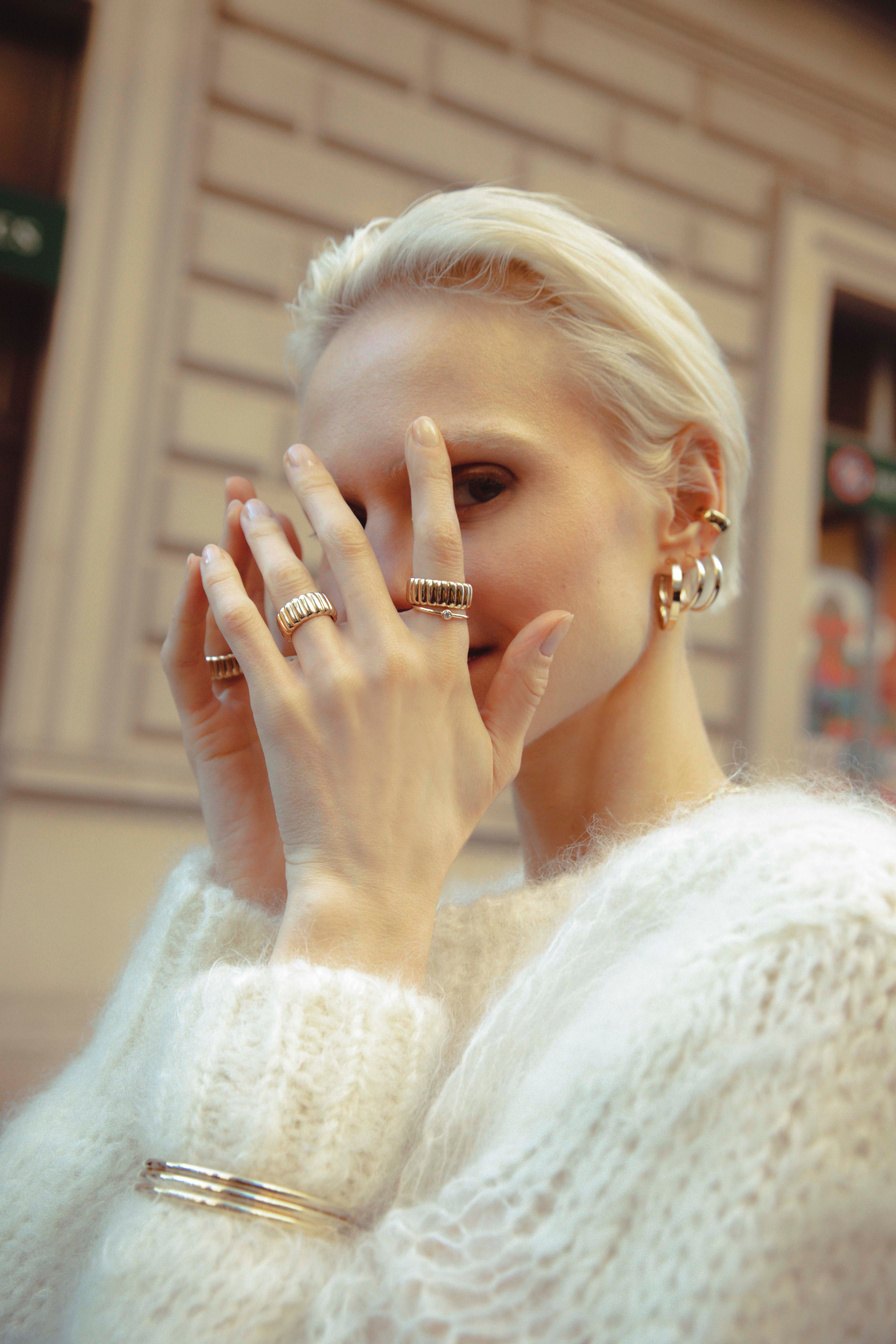 Close portrait with rings and a white knit sweater