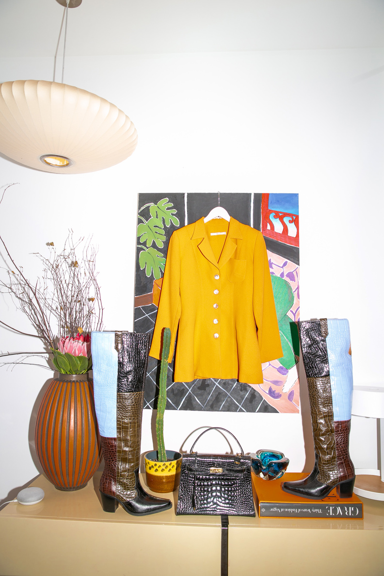 Yellow blazer, boots, handbag and flowers arranged in a room