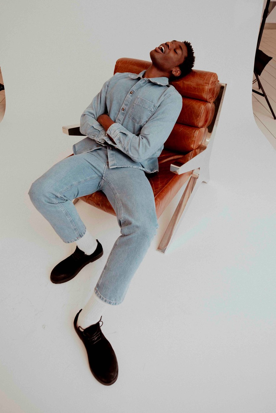 Man in denim reclining in a leather chair