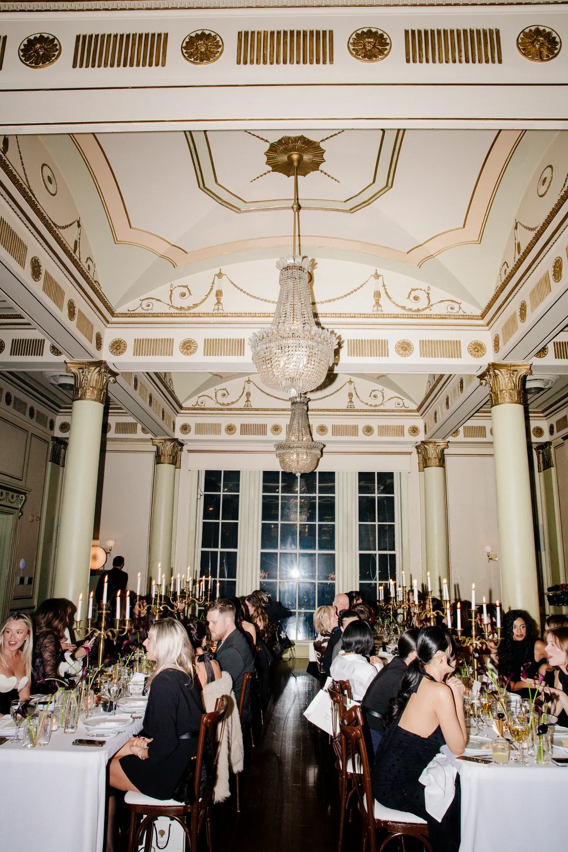 Guests seated at round tables in an ornate ballroom