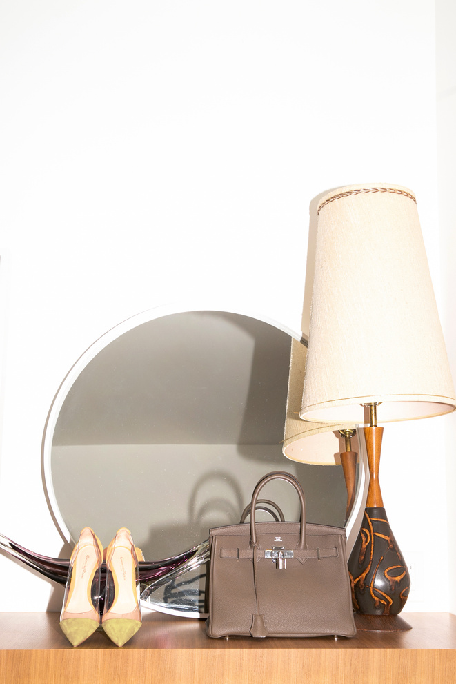 Shoes, handbag and lamp reflected in a circular mirror